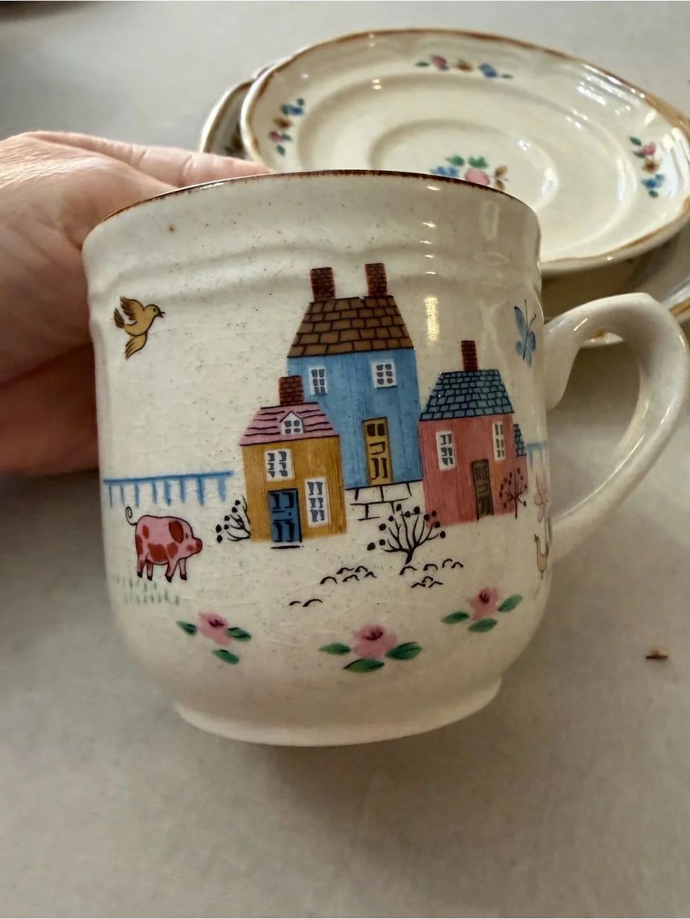 International Cream Ceramic Cup and Saucer Set with Hand-Painted Village Design
